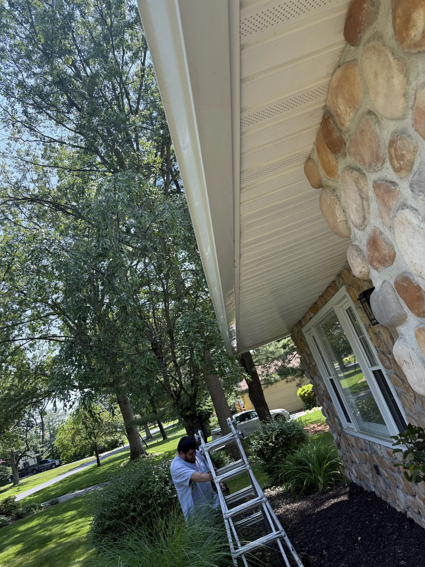 Casita crew setting up a ladder at a stone home on the Main Line